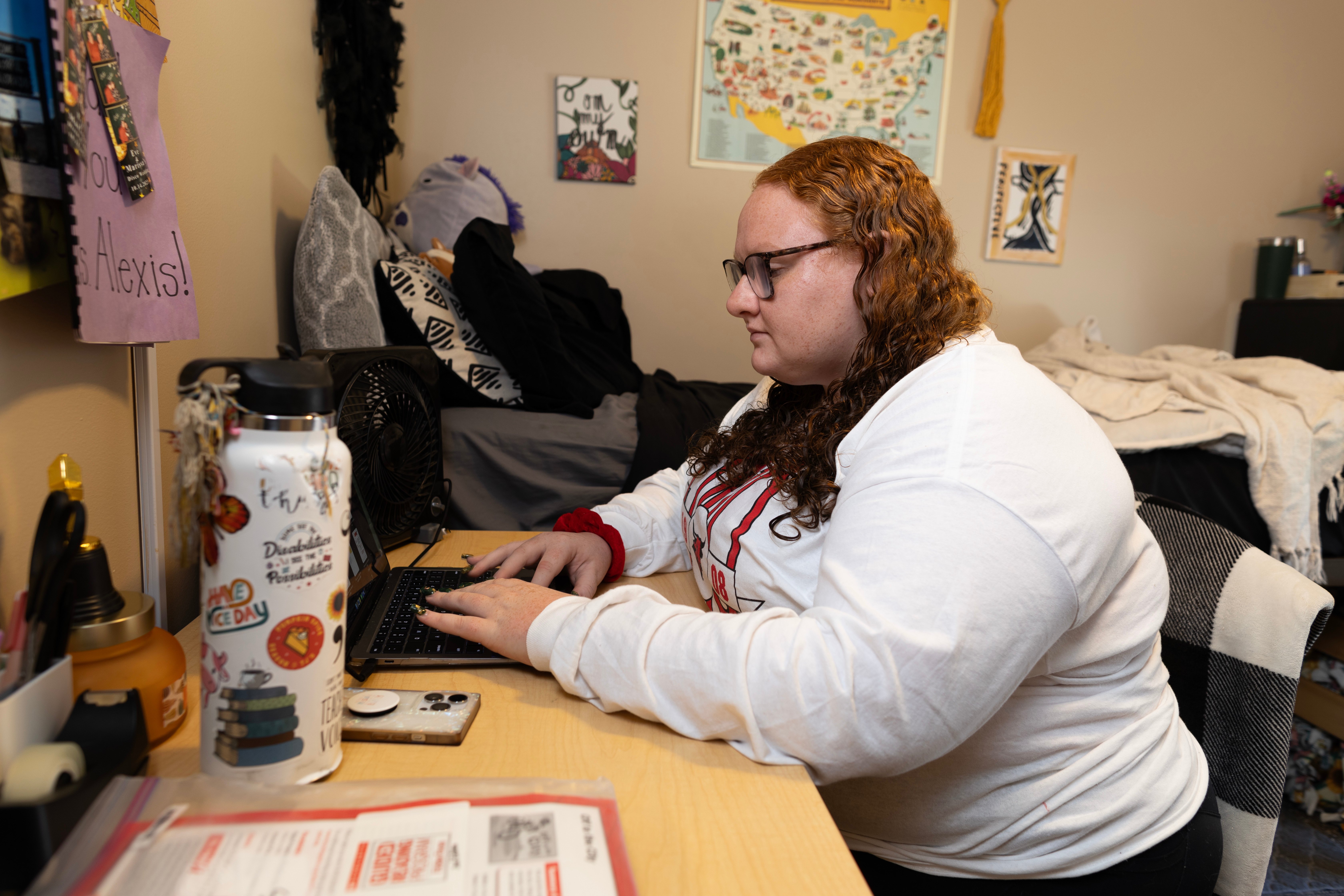 Alexis Saxton doing homework at a desk in her dorm room.