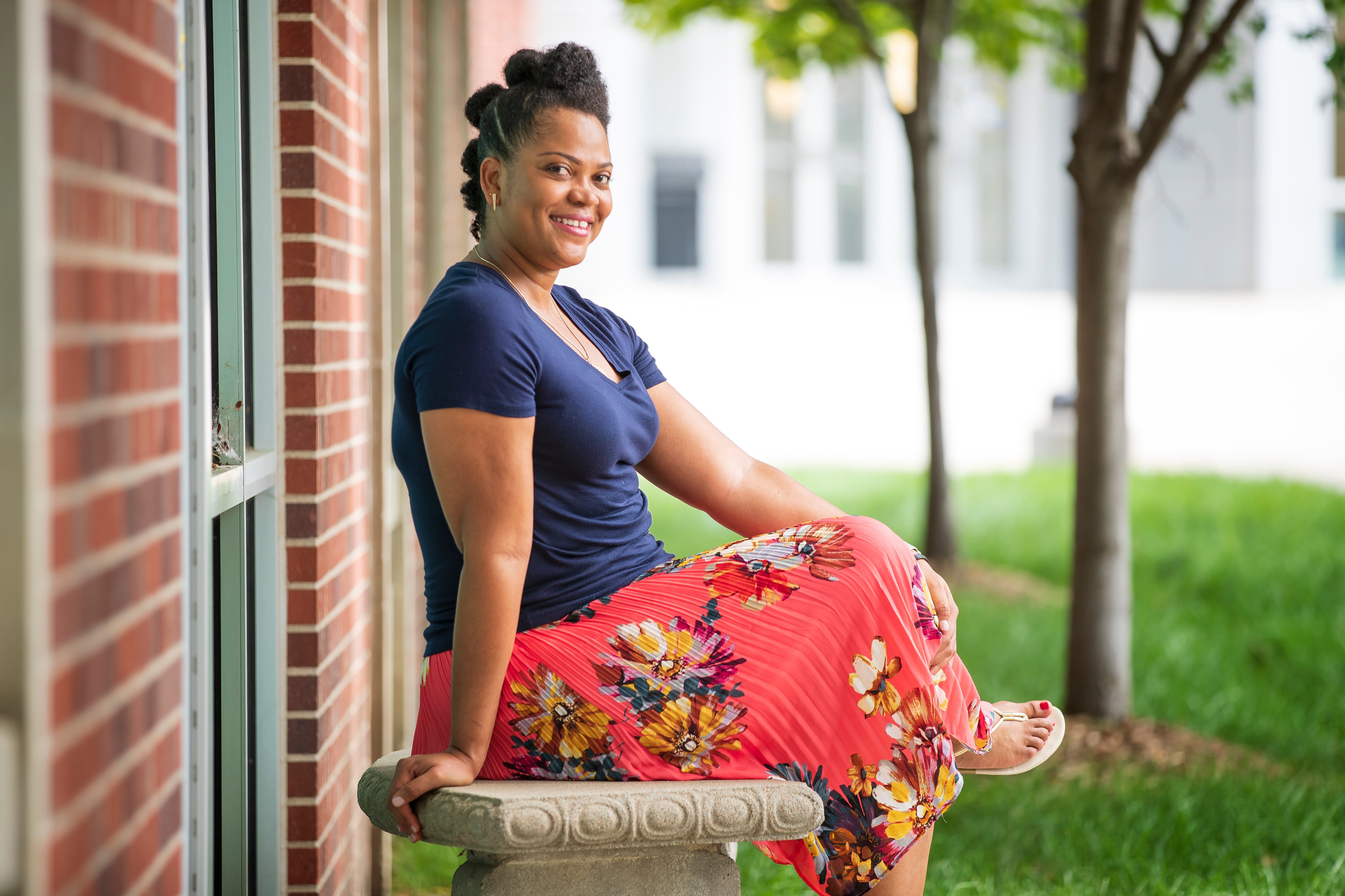 Photo of Gina Christopher posing on a bench on UNOs campus.