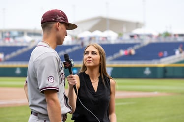 Photo of Ana Bellinghausen interviewing a baseball player at the College World Series.