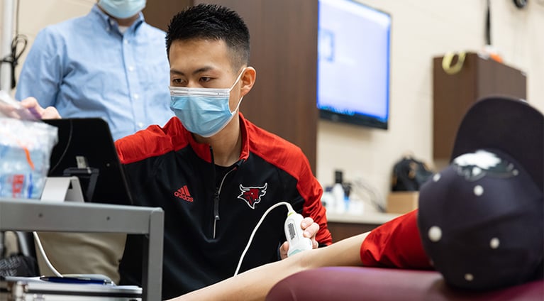 Tomohiro Ide performs an ultrasound on a pitchers arm in the lab