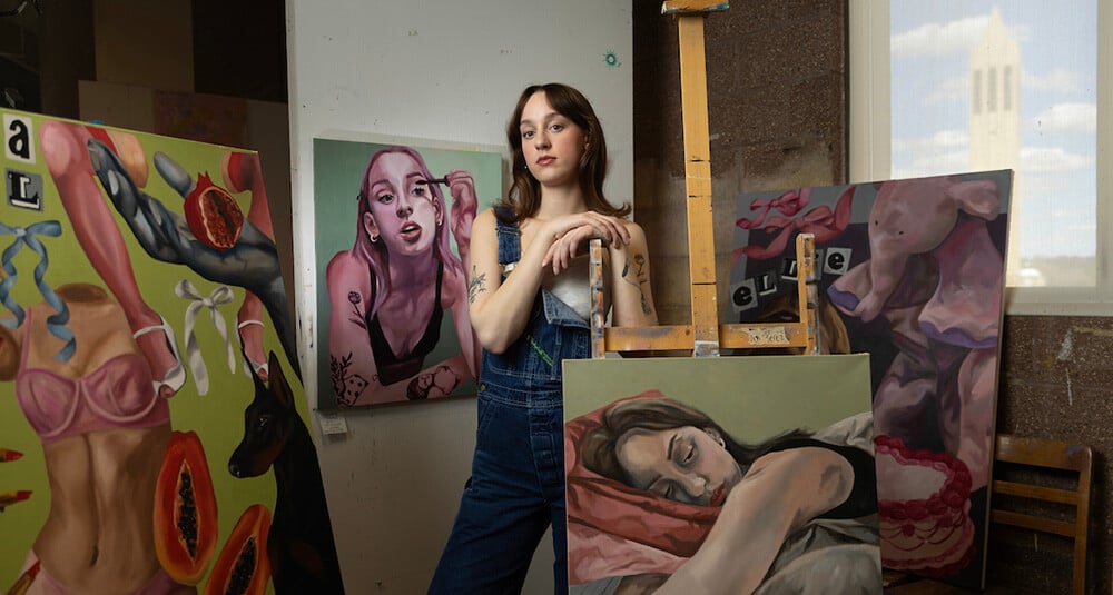 Artist and UNO student, Kennedy Wallman, poses in the studio with her recent work. 